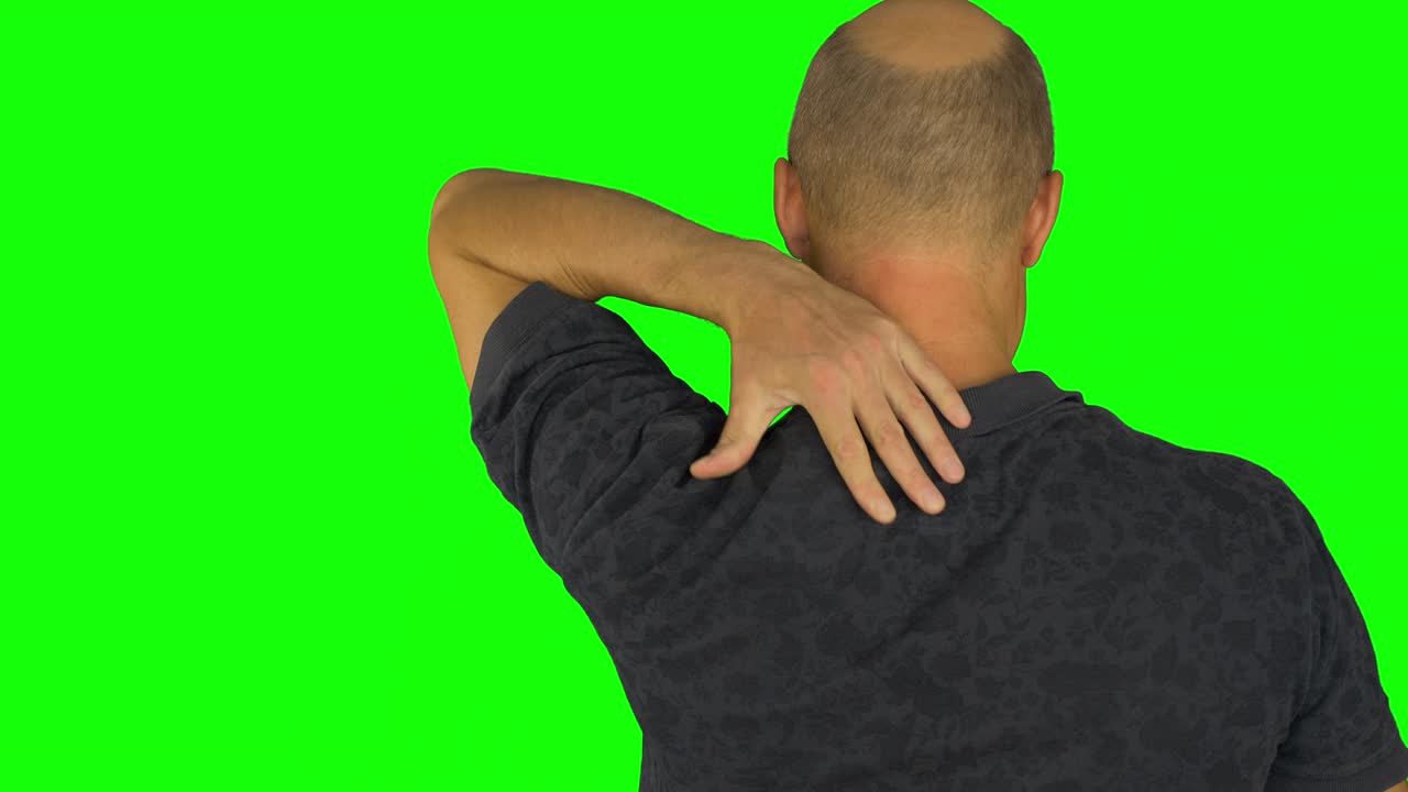 hombre frotando los hombros con la mano izquierda. vista trasera de la cintura en camisa polo.