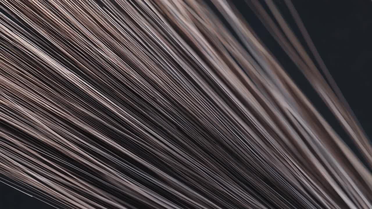 múltiples tomas macro de hebras de cabello creando una experiencia visual hipnotizante, mostrando su textura y movimiento contra un fondo oscuro