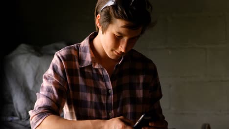 female metalsmith using mobile phone 4k