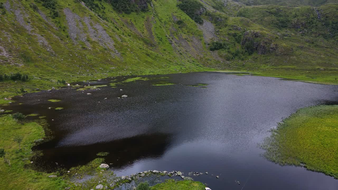 un bote de remos abandonado se sienta al borde de un lago negro espeluznante