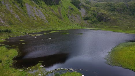 An-abandoned-rowing-boat-sits-on-the-edge-of-a-spooky-black-lake