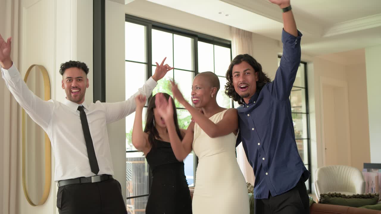 Diverse friends in formal attire standing at home by black door after joke, laughing, clapping