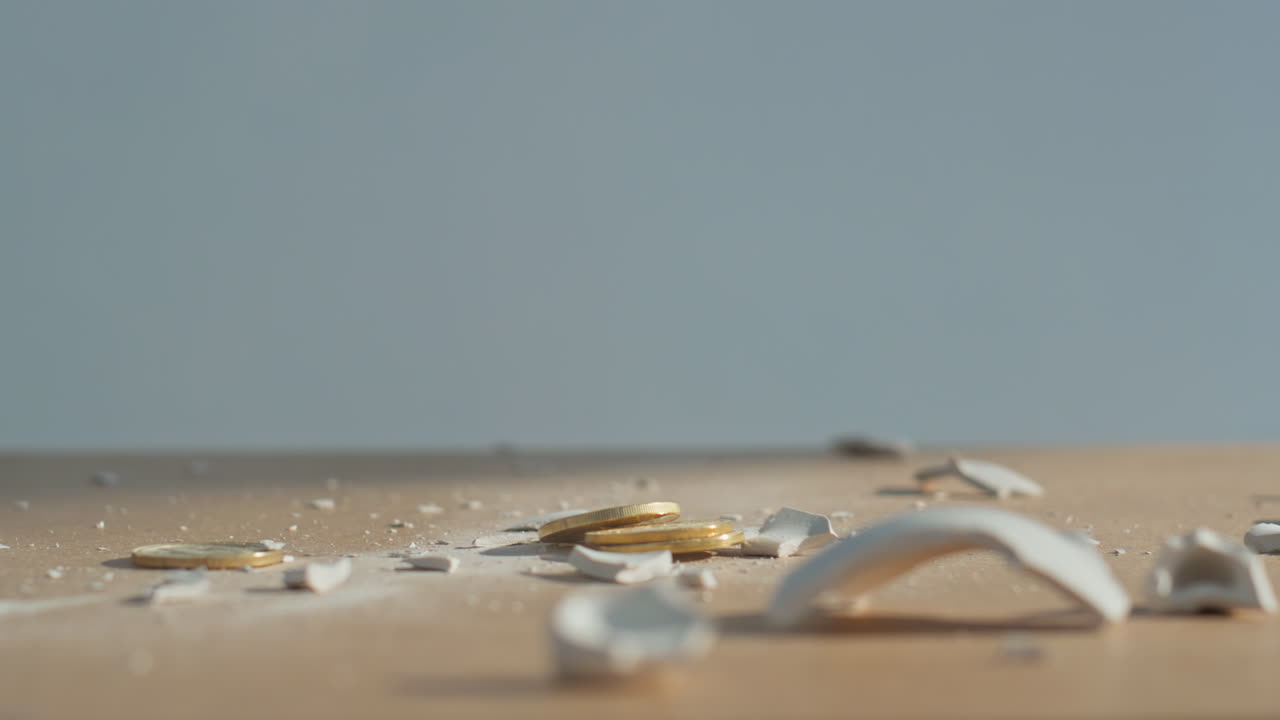 Shattered piggy bank coins scattered. Man hand breaking piggybank with hammer