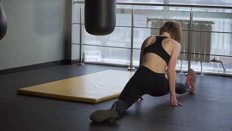 mujer estirándose en el gimnasio