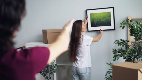 couple moving in and hanging a picture