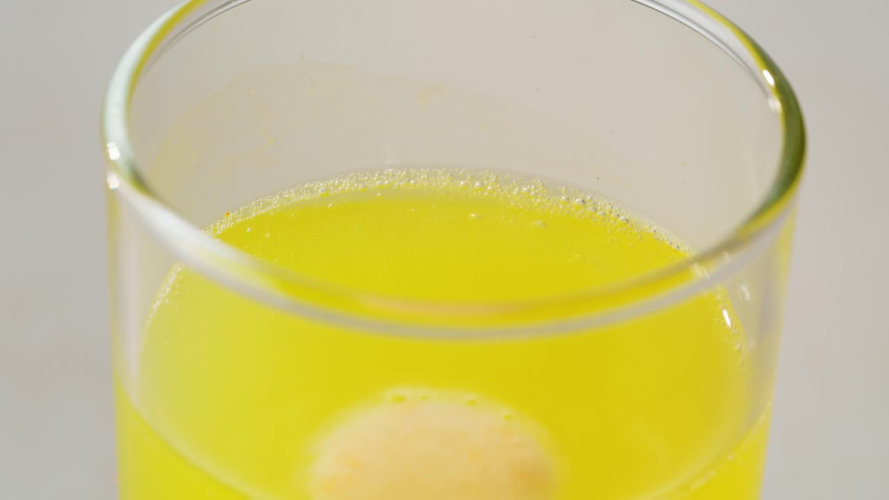 용해되는 태블릿을 가진 노란색 음료