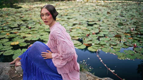 woman princess sitting lake with water lilies close up. fairytale model posing