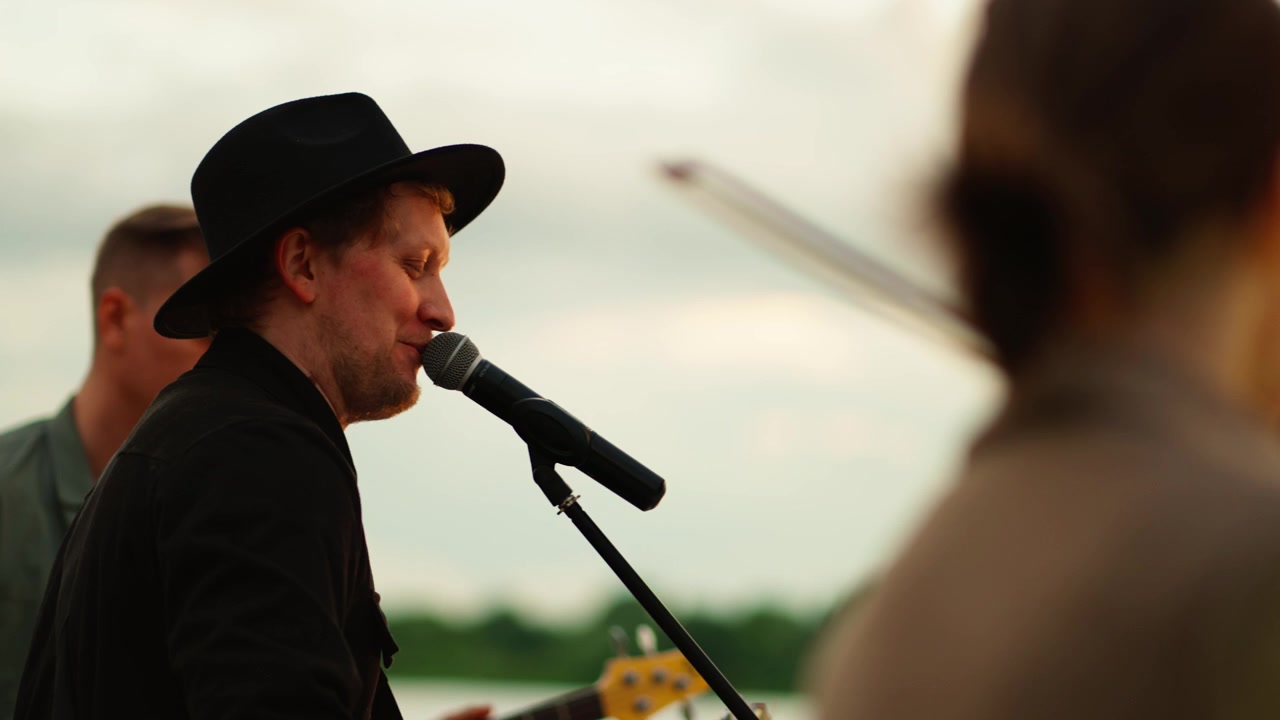 Musiker spielt Akustikgitarre und singt bei einer Open-Air-Veranstaltung