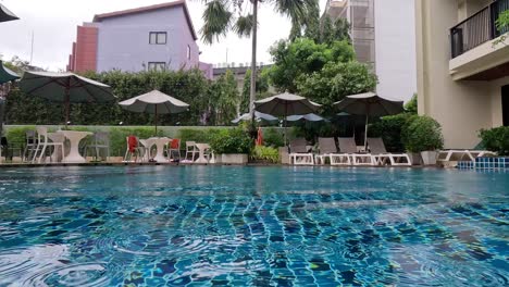 rain falls on a serene hotel pool