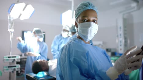 portrait of african american female surgeon using tablet in operating theatre, slow motion