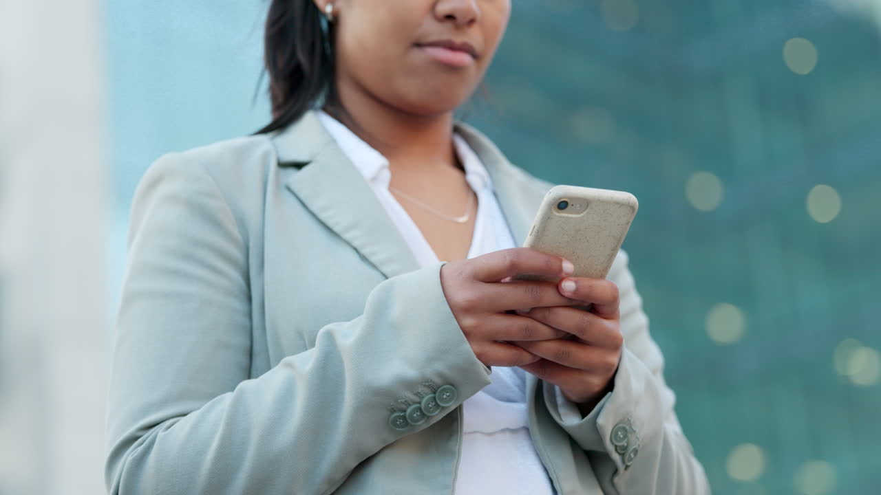 mujer de negocios enviando mensajes de texto en su teléfono inteligente en la ciudad