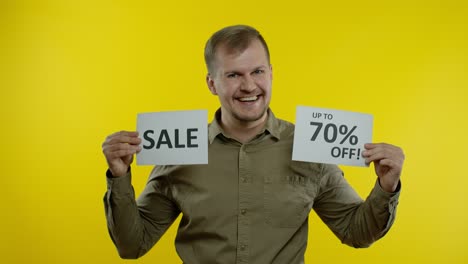 joyful man showing sale word and showing up to 70 percent off inscription. black friday concept