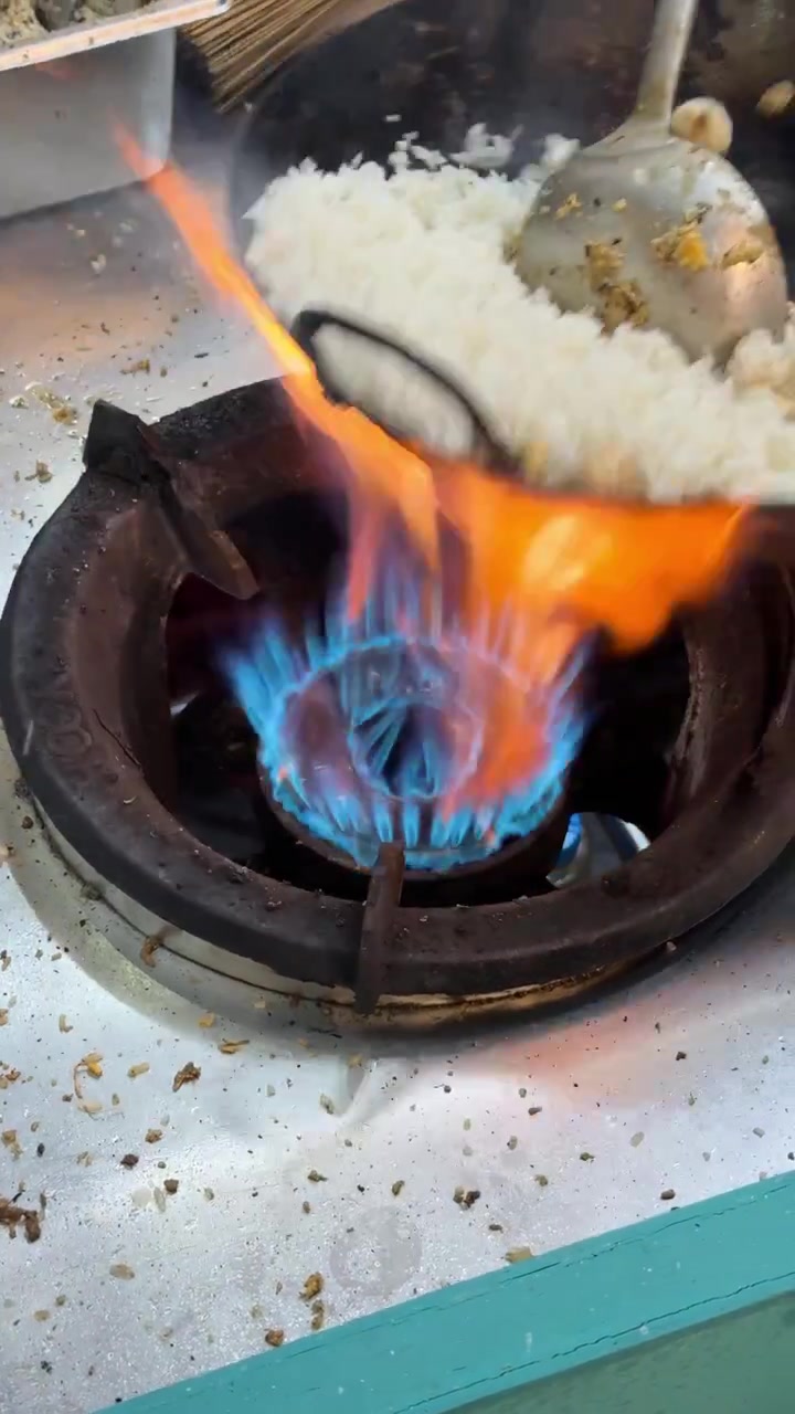Kok lynsteger ris i en wok over høj flamme