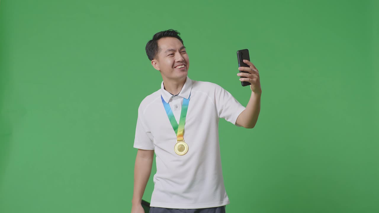 트로피와 스마트폰으로 승리를 축하하는 남자