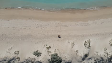 Desciende-La-Toma-De-Arriba-Hacia-Abajo-De-Una-Persona-Que-Se-Relaja-En-Una-Playa-De-Arena-Frente-Al-Océano-Australiano-Durante-El-Verano