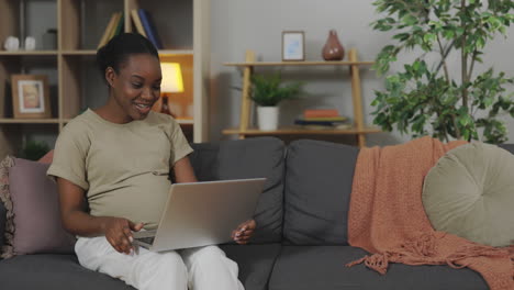pregnant woman working on laptop at home