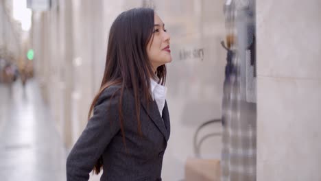 Attractive-young-woman-window-shopping-in-town