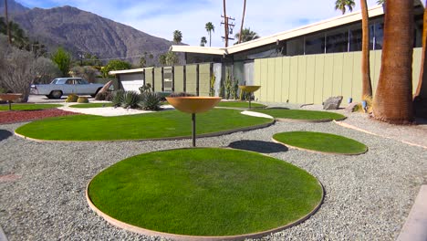 toma exterior de establecimiento de una casa moderna de mediados de siglo en palm springs, california, con autos retro clásicos estacionados afuera 5