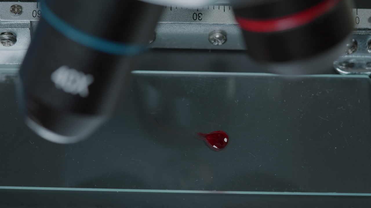 Micro pipette putting blood sample on microscope to test dna
