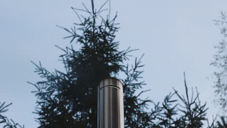 Close-Up-Of-Stainless-Steel-Chimney-With-Smoke-Rising-From-Furnace-Outdoor