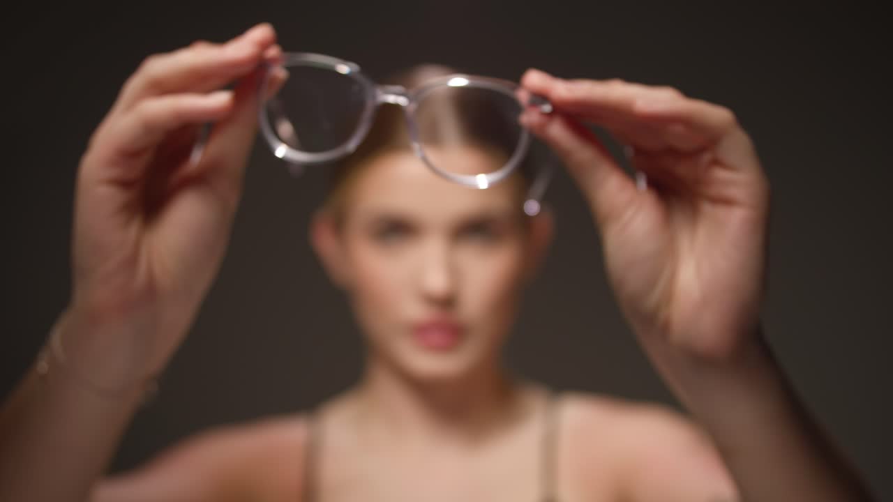 el enfoque del estante, la mujer se pone gafas modernas, concepto de visión aguda, gafas