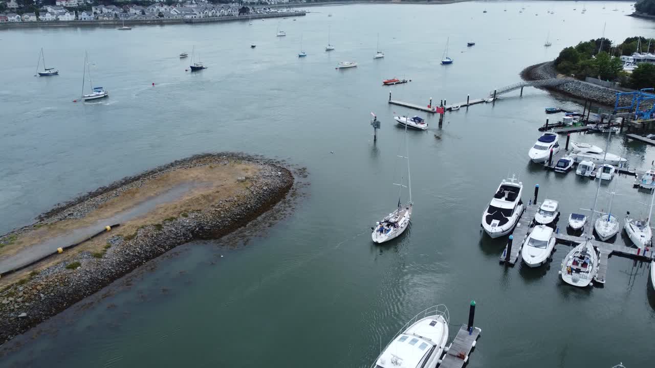 vista aérea descendiendo al barco saliendo del puerto deportivo de yates ricos navegando en un velero caro de lujo frente al mar