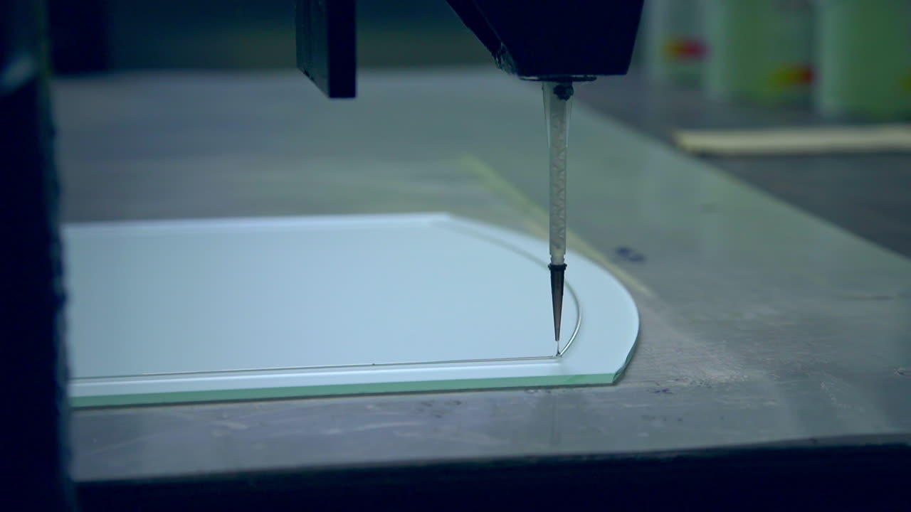 Applying lines picture on the glass elements of door. Machine moves and leaves a thin line on the glass. Door manufacturing plant.