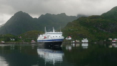 car ferry approaching the dock in the lofoten islands on a cloudy summer day, moskenes, norway