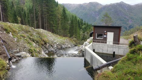 small dam and water intake for a mini hydroelectric powerplant called markaani in vaksdal norway - intake high up in the mountains with valley and natural mountain background