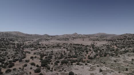 4k drone shot of alhama de granada, spain, filmed with a dji at 30fps. a cinematic backward flight over an arid prairie, showcasing the vast, semi-desert landscape and rugged terrain.