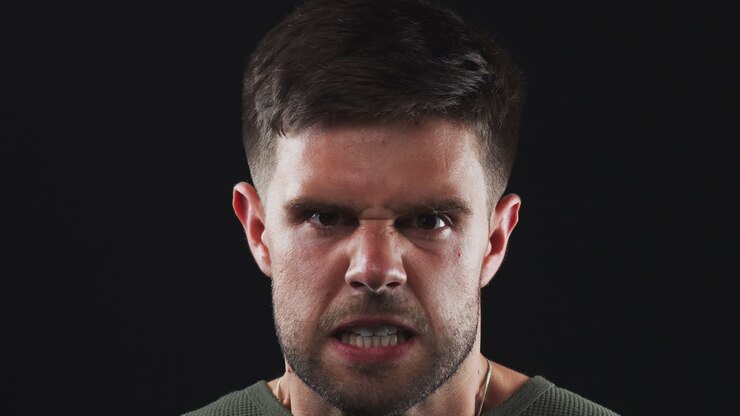 Head And Shoulders Studio Shot Of Angry Man Shouting At Camera In Slow Motion