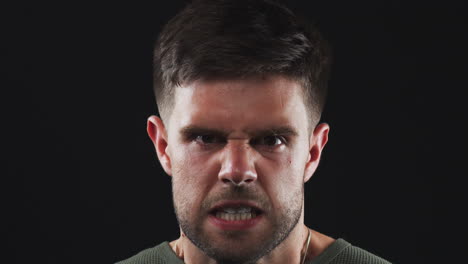 head and shoulders studio shot of angry man shouting at camera in slow motion