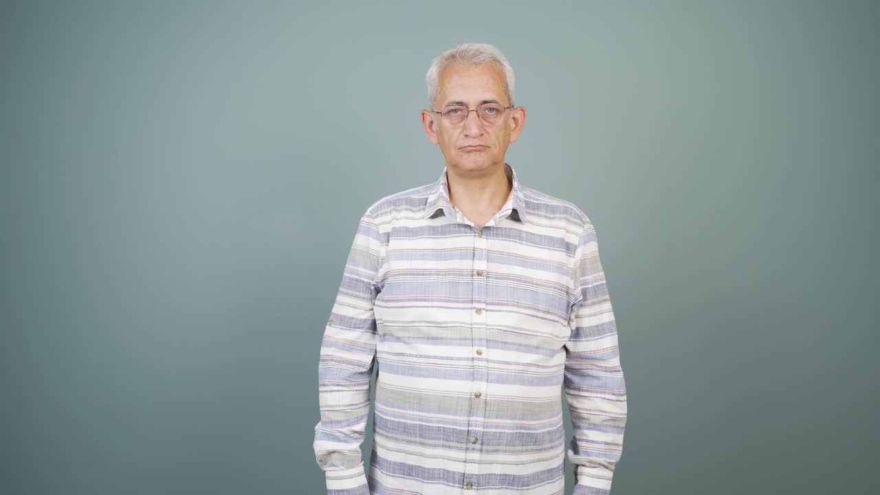 부정적인 표정으로 카메라를 바라보는 남자.