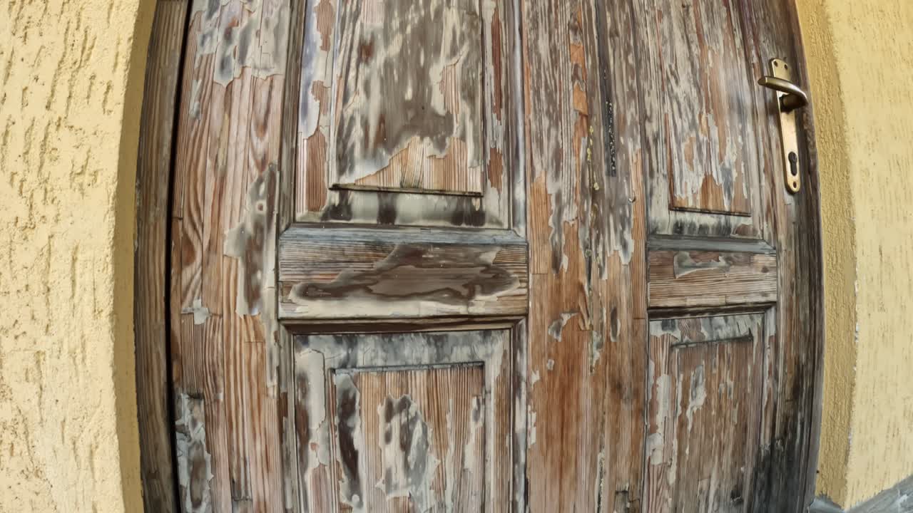 Varnish peeling off a wooden door. Lacquer coating degredaing over time.