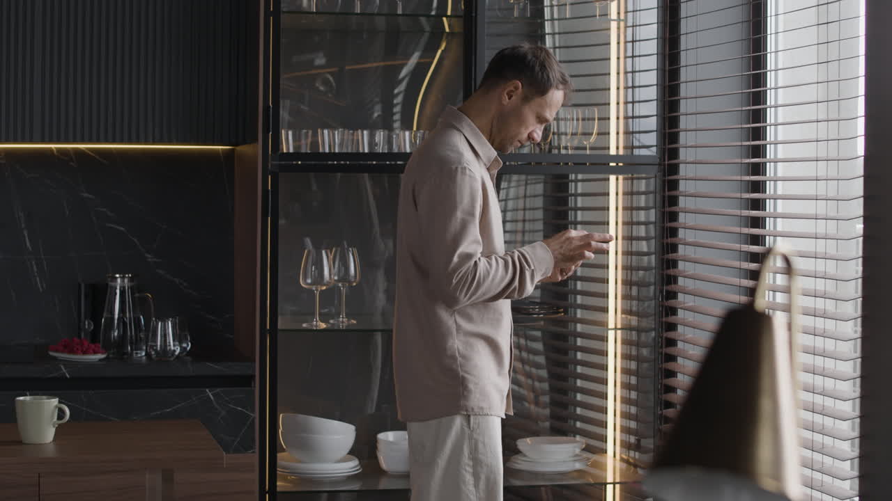 Man in modern kitchen using phone