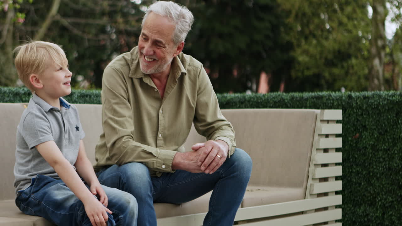 Grandfather and grandson talking on a bench