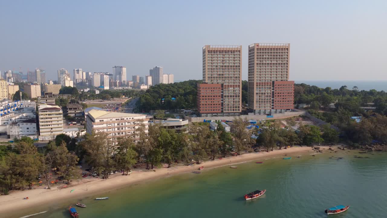 Vista aerea di uno sviluppo sul lungomare a Independence Beach con edifici a molti piani, litorale urbano e barche ancorate, che mostra una rapida crescita costiera e l'espansione della città moderna.