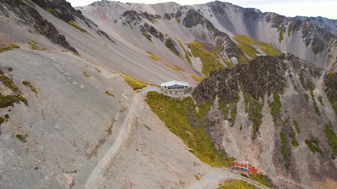 Aerial view tilting away from a lodge in mountains of Cragieburn, New Zealand