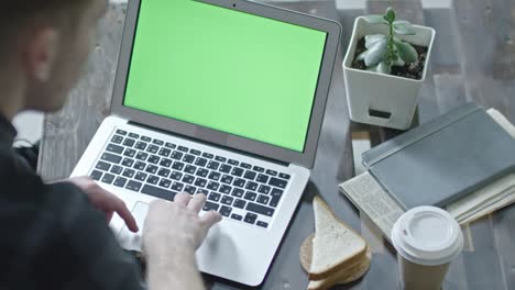 office worker browsing the net on laptop with chroma key screen