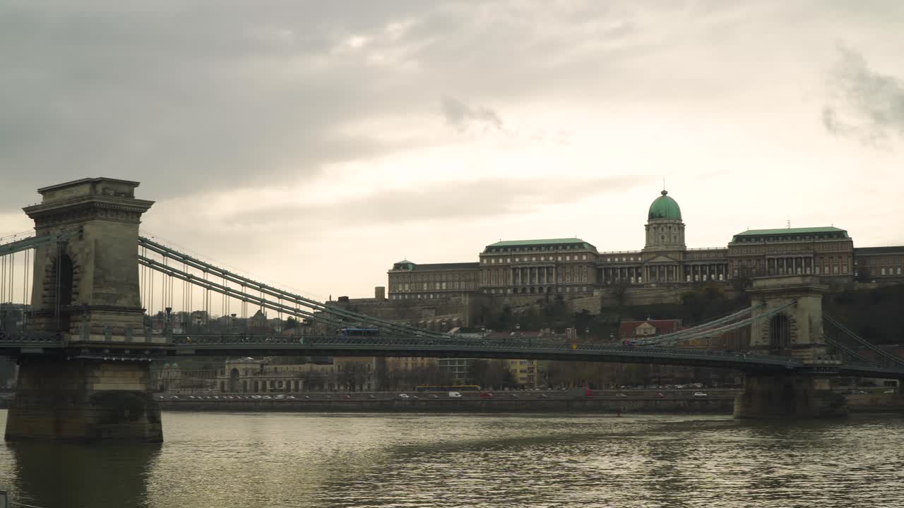 The Iconic Szechenyi Chain Bridge Spanning Over Danube River In Budapest Hungary Near The Historic Buda Castle Under The Cloudy Sky - Panoramic Shot