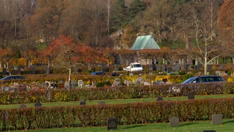 cars driving at the kviberg cemetery in gothenburg, sweden during autumn season