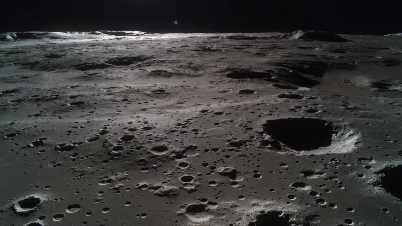 Cámara moviéndose mostrando la superficie lunar craterizada, revelando un gran cráter inferior derecho, una cresta y un cielo oscuro.