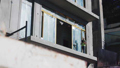 construction worker inspecting a modern apartment building under construction