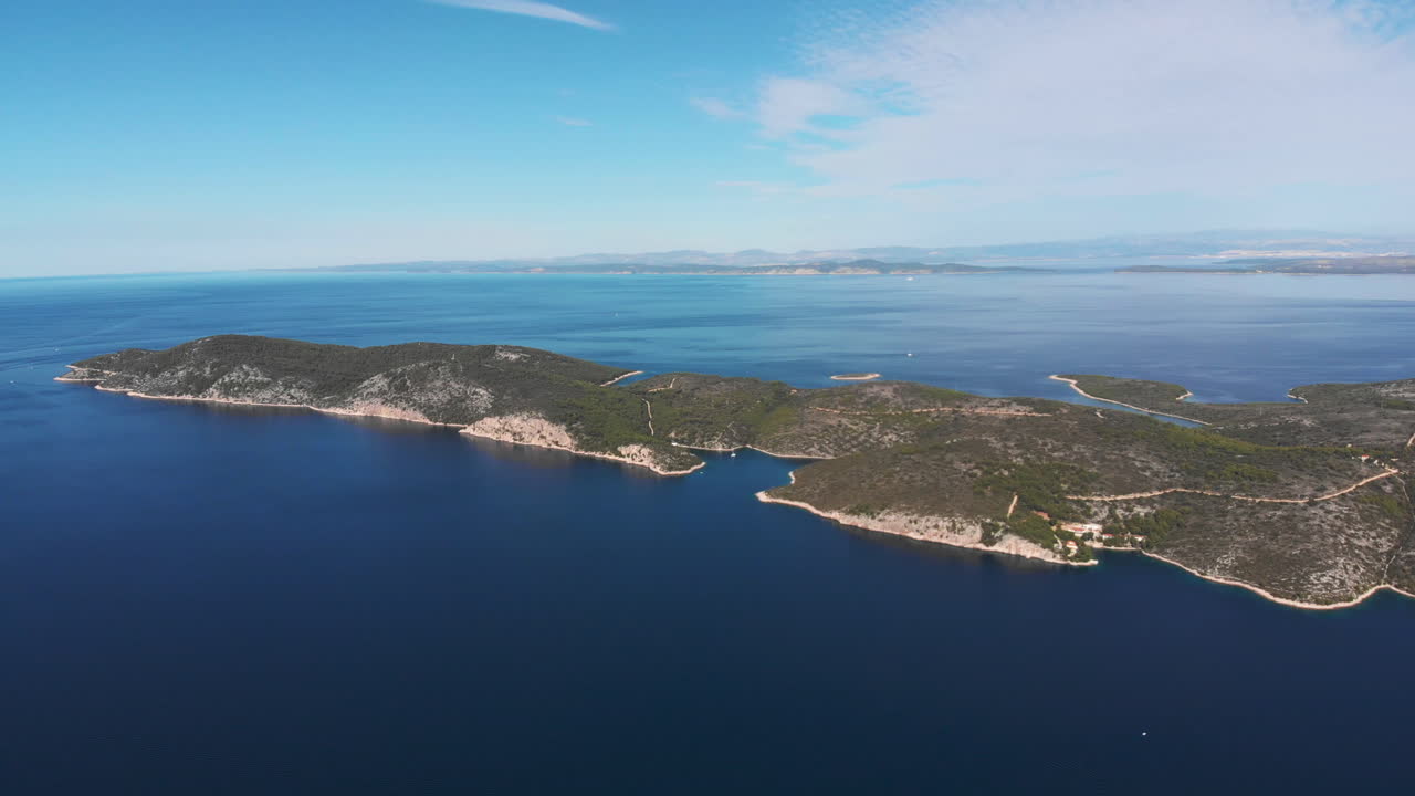 Panning over the beautiful blue Adriatic sea to reveal several little islands and the big island of Hvar