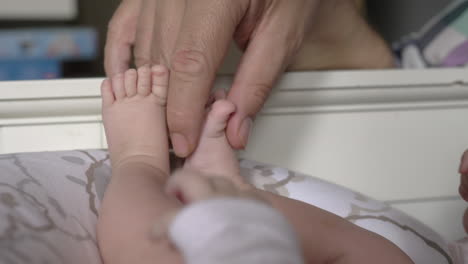 Padre-Jugando-Con-Los-Pies-De-Su-Hija-Recién-Nacida