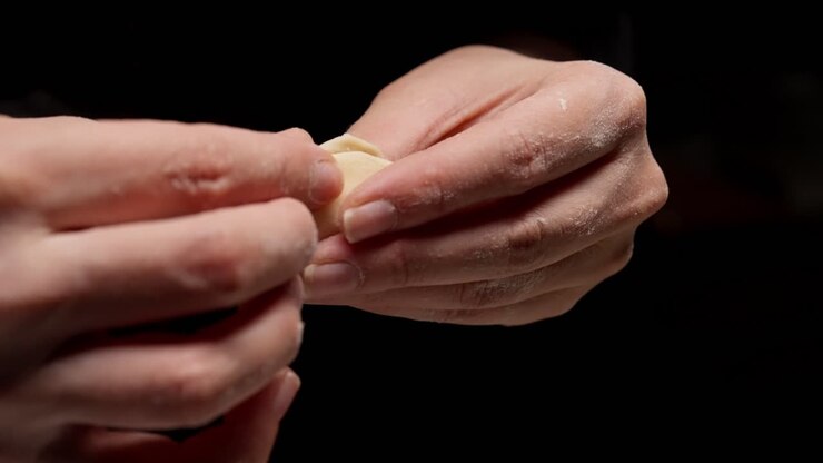 Close-up of Hands Folding a Dumpling with Filling