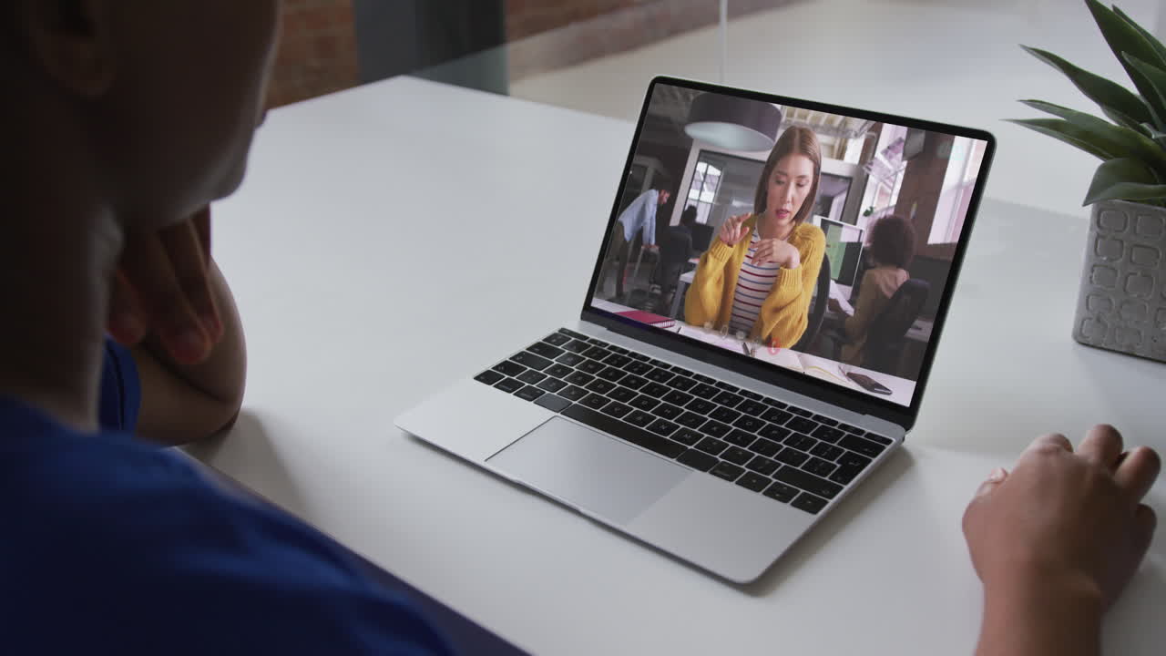 Mid section of african american woman having a video call on laptop with female colleague at office