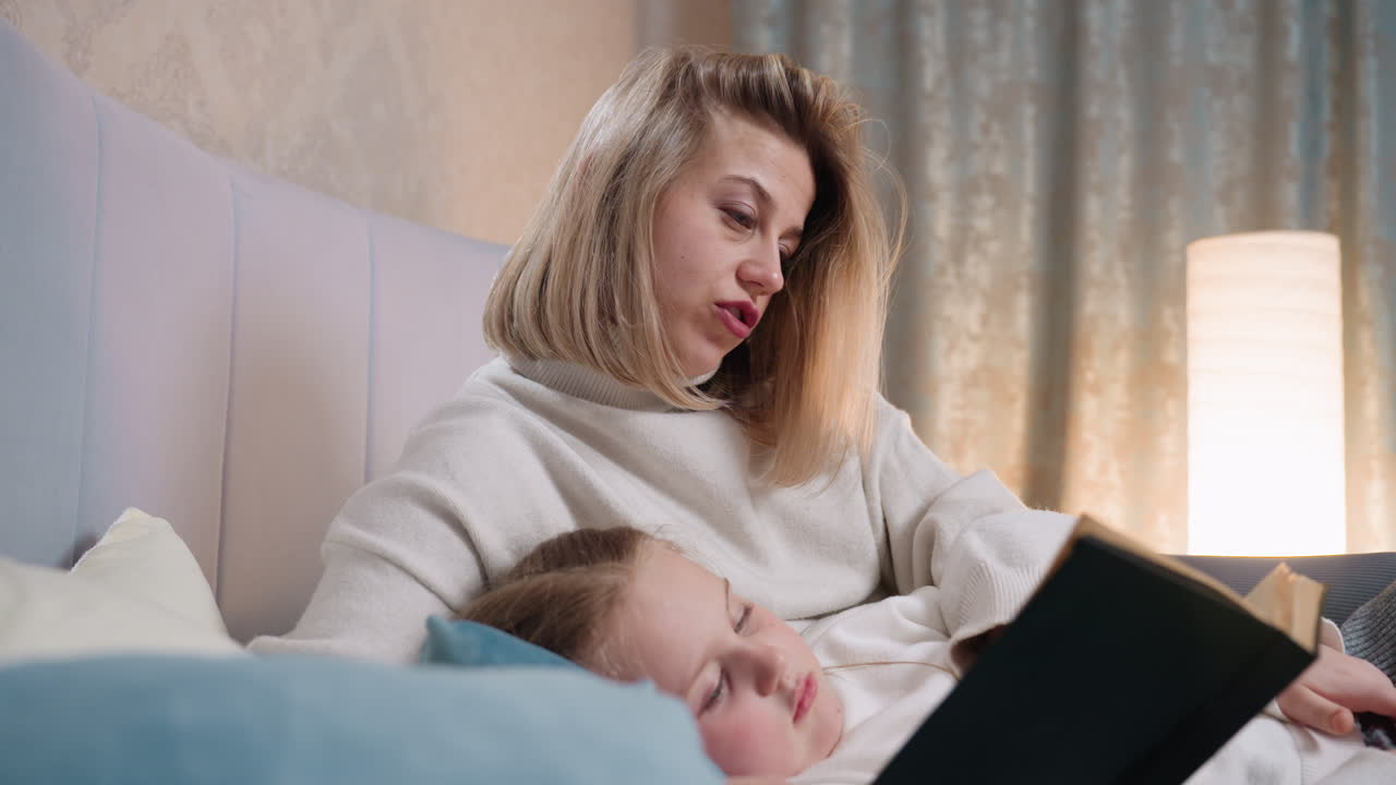 Mother reading book while child rests on her in cozy bedroom, creating intimate family bonding moment filled with tenderness, warmth, comfort, and emotional connection,care, and nurturing atmosphere