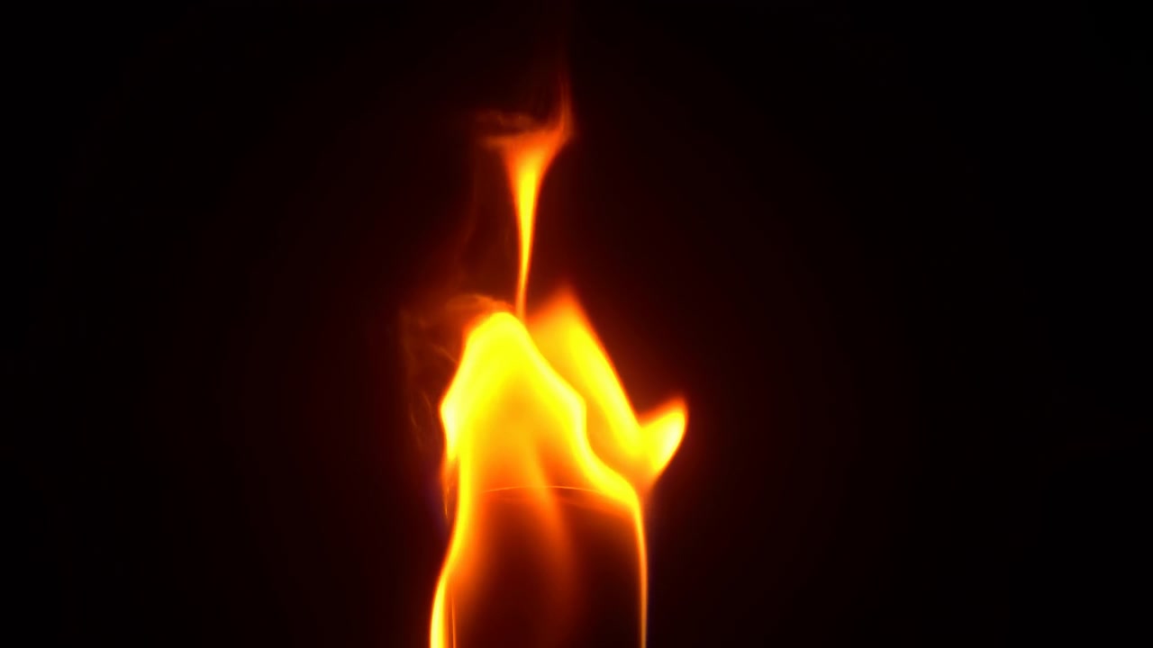 Frontalt nærbillede af en enkelt lys orange-gul flamme, der stiger op fra en lille mørk, afrundet brændstofkilde, og viser lodret søjleforlængelse, skiftende flammeformer, krøllet spids, glødende kanter og blød røg.