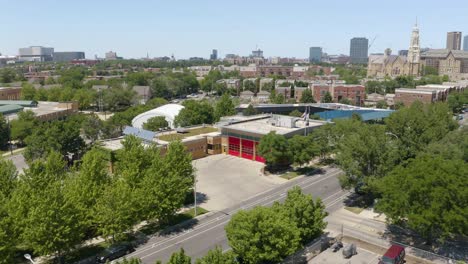 drone vuela lejos de la estación de bomberos de chicago para revelar el horizonte de la ciudad en el día de verano